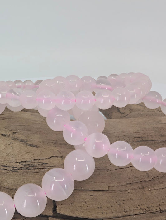 Close-up of 9mm, 8mm, 6mm Pink Calcite beads showing translucent pastel glow