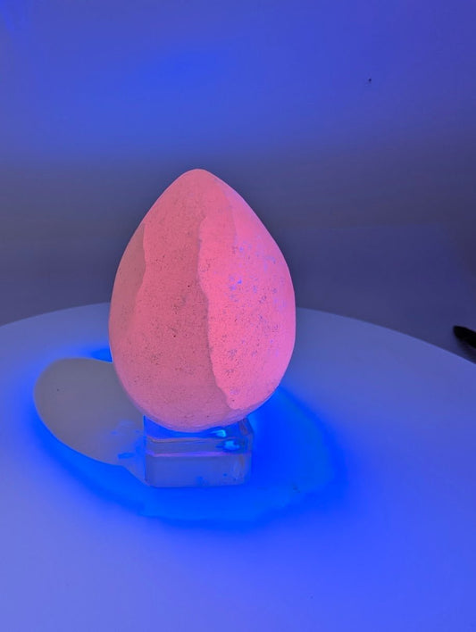 Pink calcite egg showing natural fluorescence under UV light