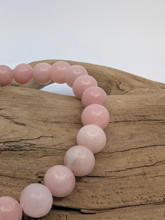 Close-up of polished Pink Opal beads with soft luster