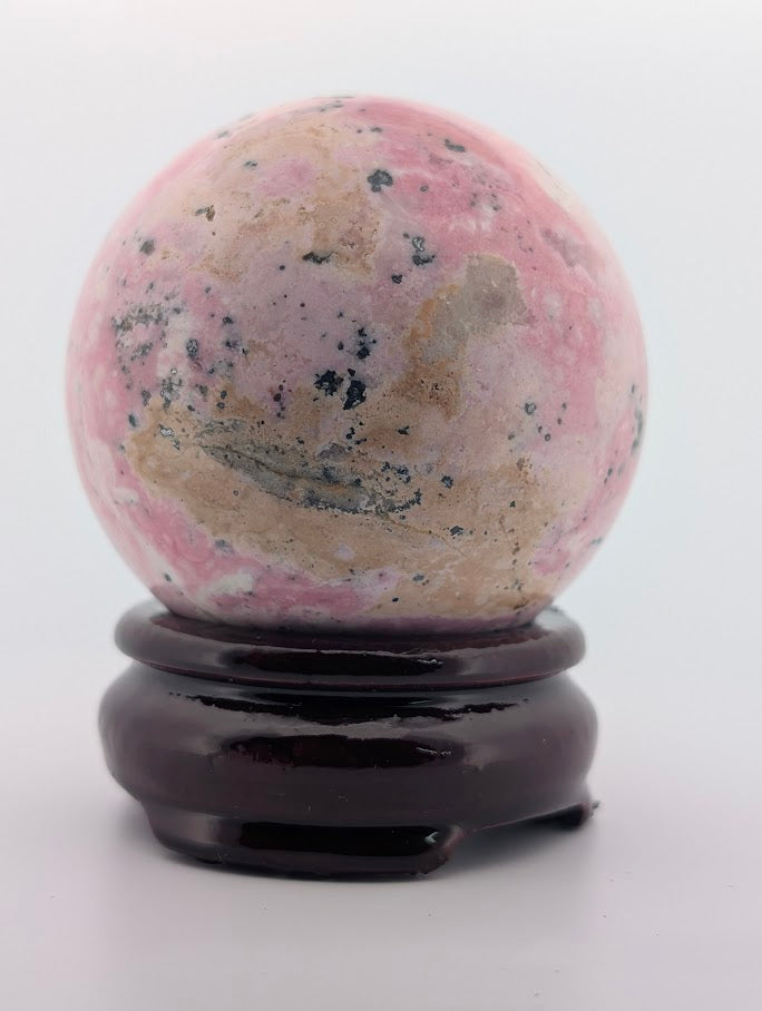 Rhodonite sphere highlighting rose-pink color zones and matrix