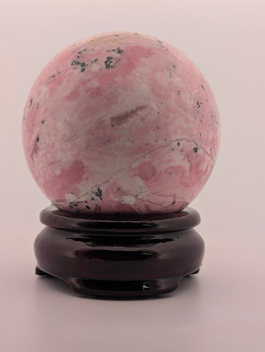 Pink Peruvian Rhodonite sphere – front view showing soft pink and white swirls