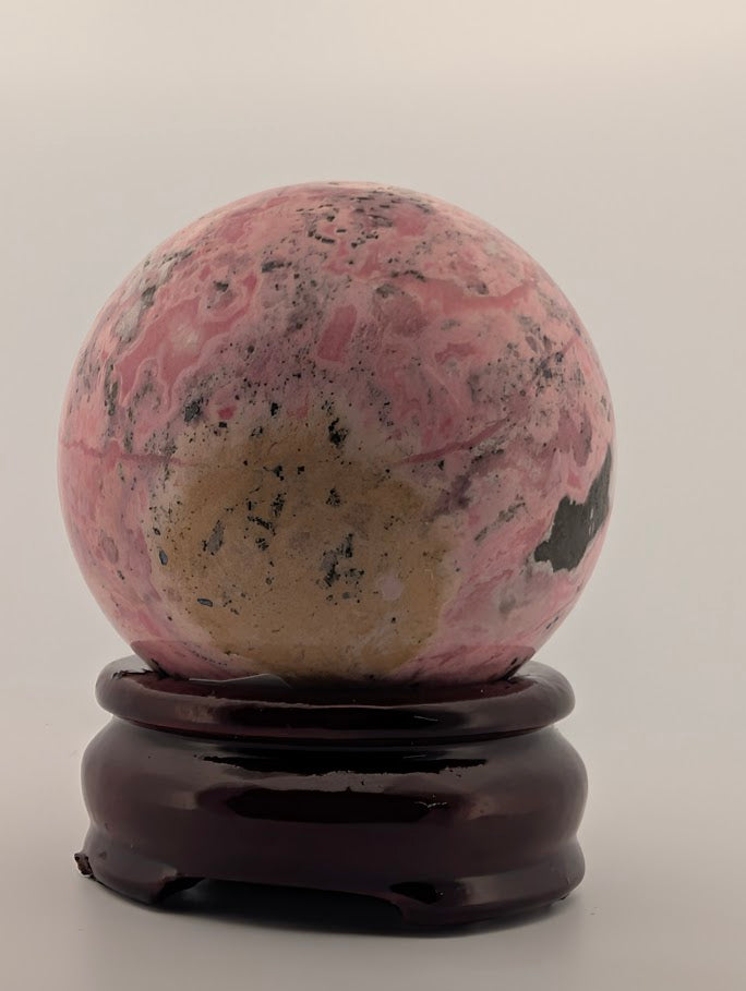 Side angle of polished rhodonite sphere with bold contrast