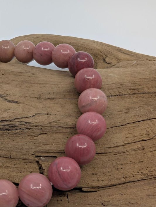Close-up of pink petrified wood beads showing natural grain