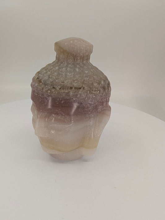 Pink Pistachio Calcite Buddha head carving, 9 cm, angled side view