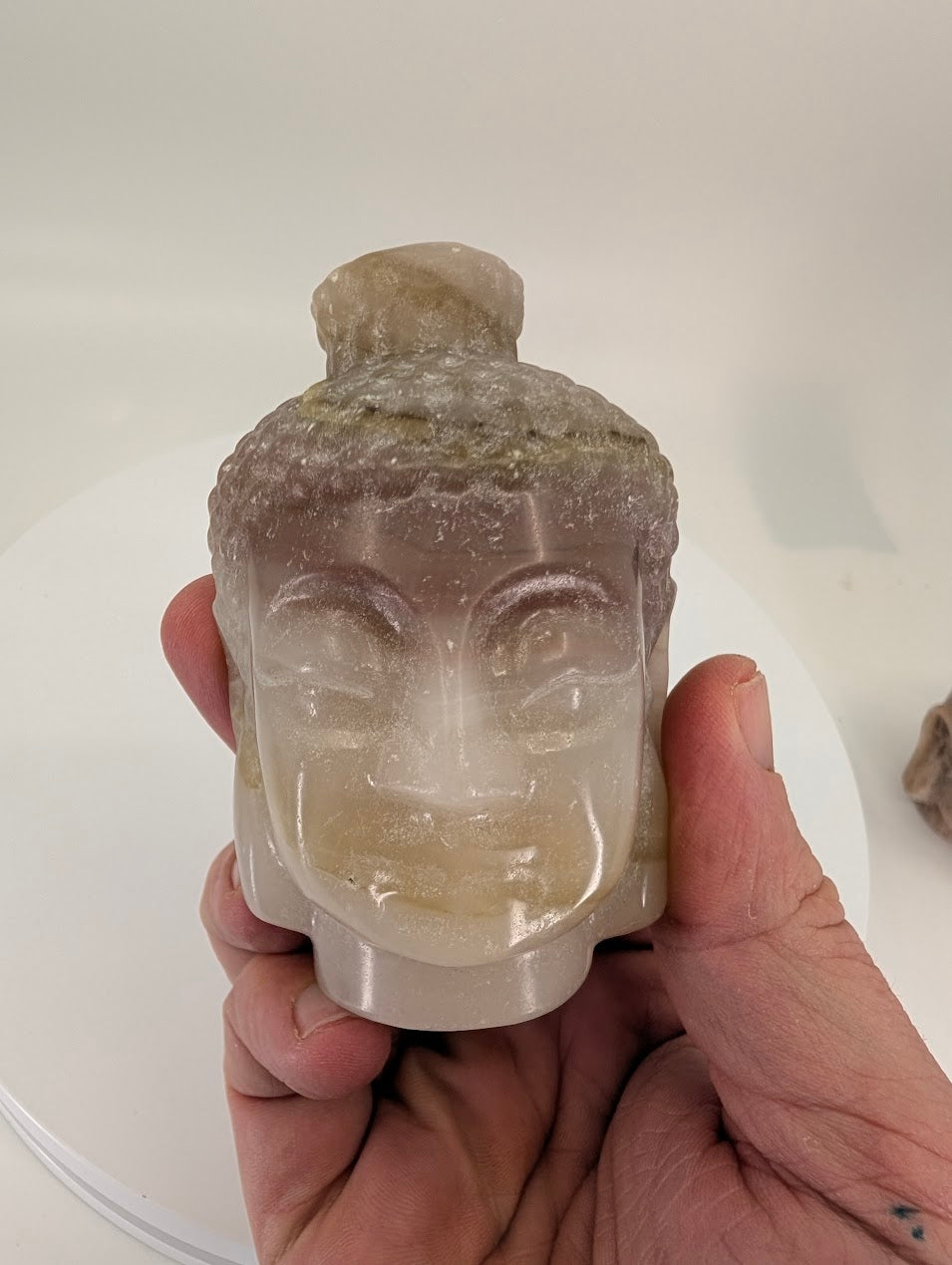 Closeup of Pink Pistachio Calcite Buddha head showing natural banding