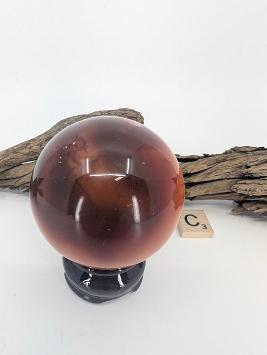 Side view of a highly polished red Windalia Radiolarite sphere.