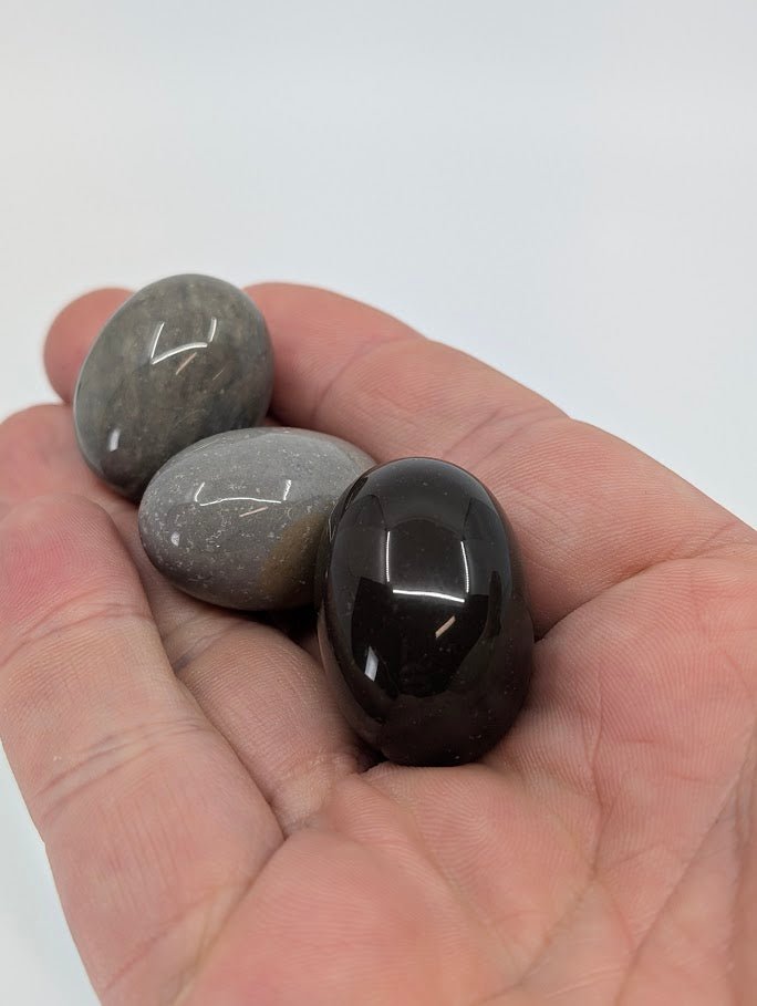 Polychrome Jasper tumbled stones in hand for scale