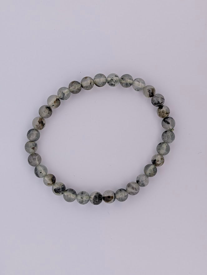 6mm Prehnite stretch bracelet, top-down, pale green with smoky and dark mossy inclusions.