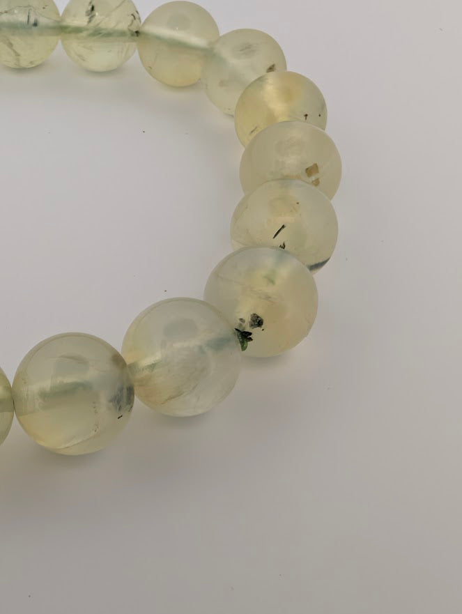 Detail of 8mm Prehnite beads highlighting translucent glow and epidote threads.