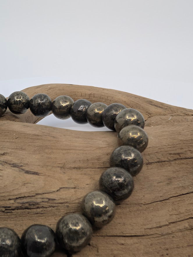 Close-up of polished pyrite beads showing natural gold and charcoal tones