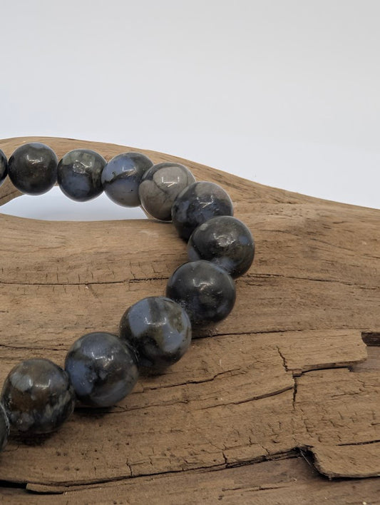 Macro of Que Sera beads with slate-grey base and blue orbicular patches