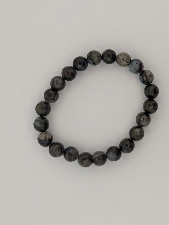 Overhead view of Que Sera 8mm bracelet on white background