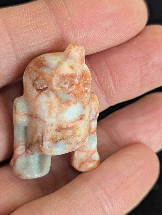 Front view of a 3cm R2-D2 carved from natural, mottled pink and white Jasper.