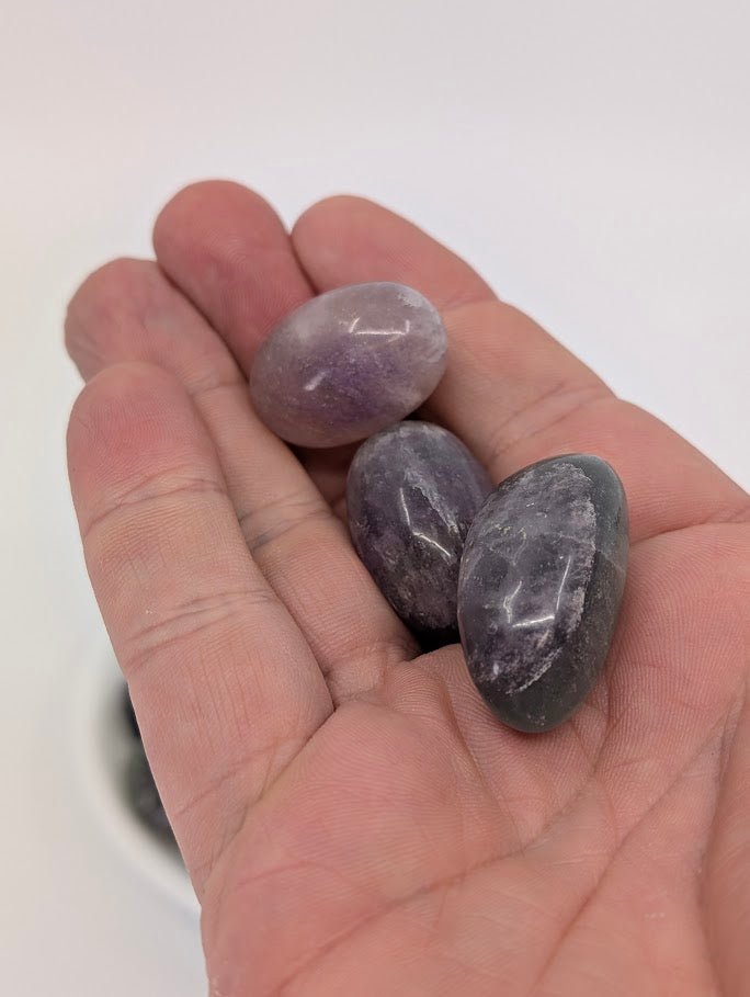Rainbow Fluorite tumbled stones shown in hand for size reference