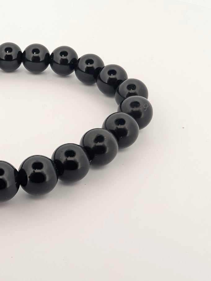 Detail of rainbow obsidian bracelet highlighting glossy finish and depth