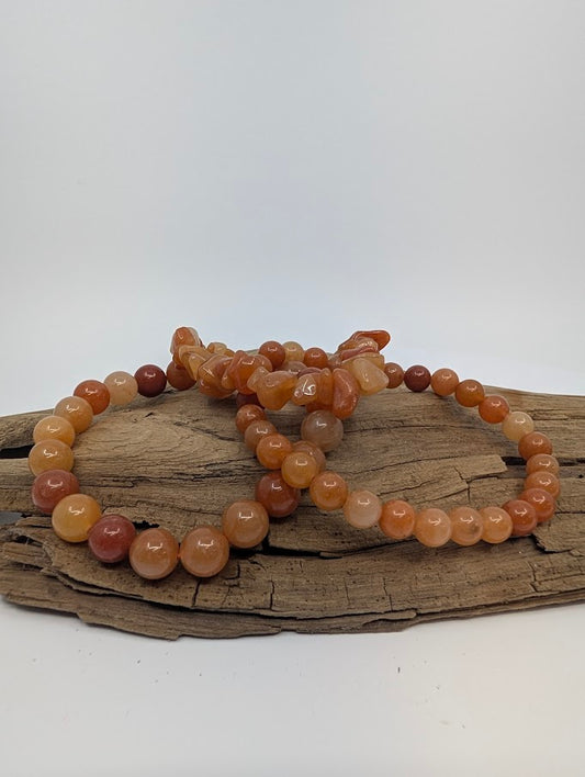 Chip, 6mm and 8mm red aventurine bracelets displayed on driftwood