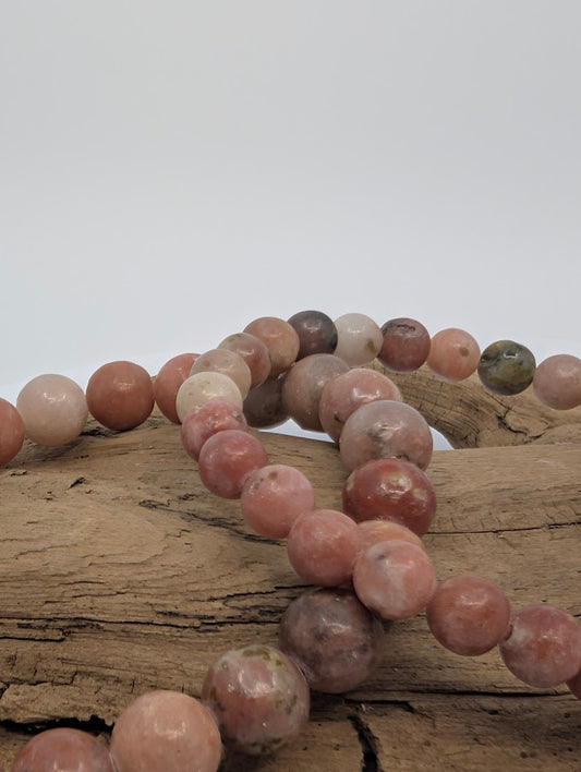 Two red aventurine bracelets with septarian inclusions displayed on driftwood