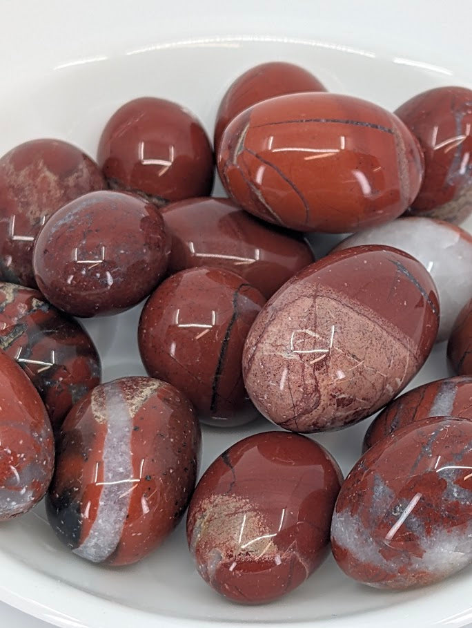 Close-up of polished Red Jasper tumbles showing color and veining