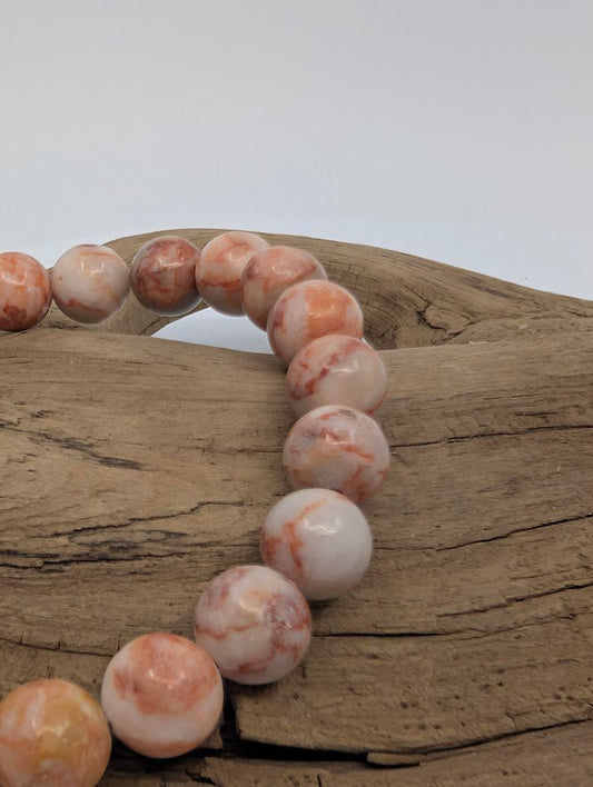 Close-up of natural Red Vein Jasper 8mm beads, high-polish finish