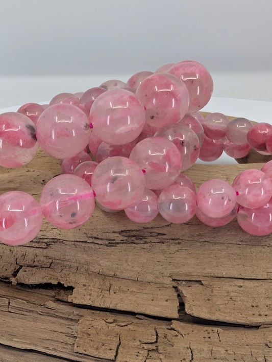 Close-up of Madagascar rhodonite beads showing natural pink coloration and internal mineral inclusions