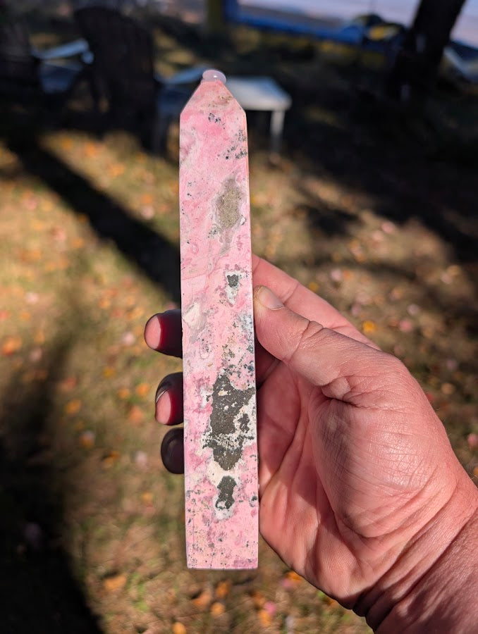 Rhodonite tower alternate side — bold manganese veining on saturated pink background