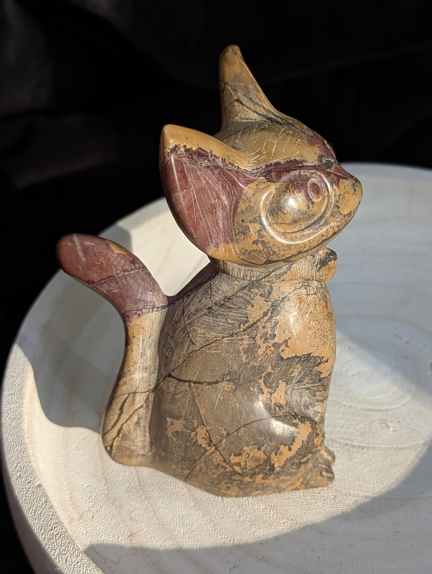Hand-carved Picture Jasper crystal cat figurine wearing a bowtie, displaying natural tan and reddish-brown banded earthy patterns, sitting upright.