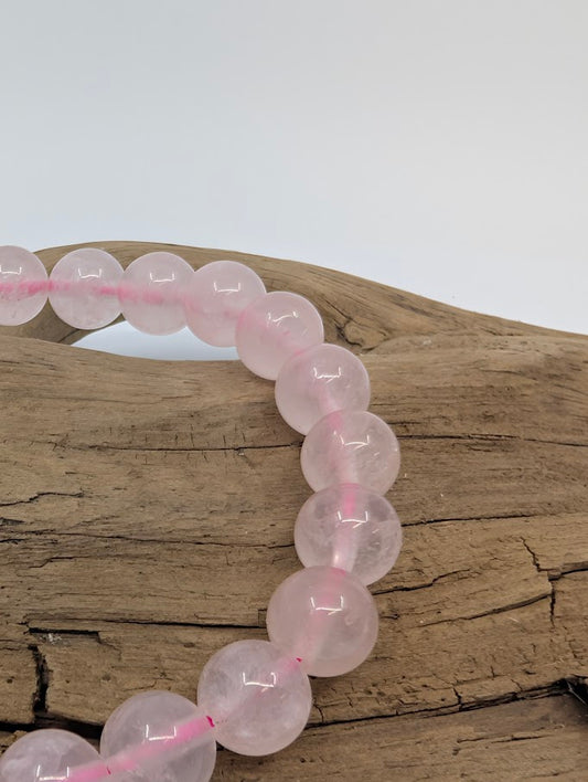Closeup of polished 8mm rose quartz beads showing translucent silky veils