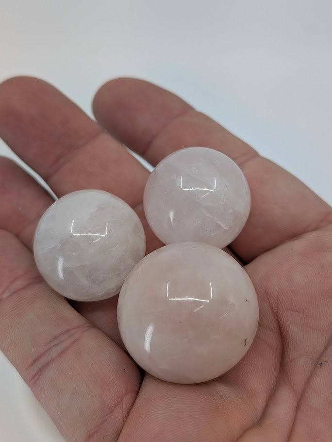 Rose Quartz mini spheres held in hand for size reference