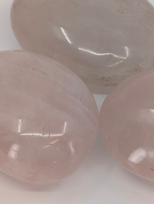 Rose Quartz palm stones grouped together showing soft blush tones and smooth polish