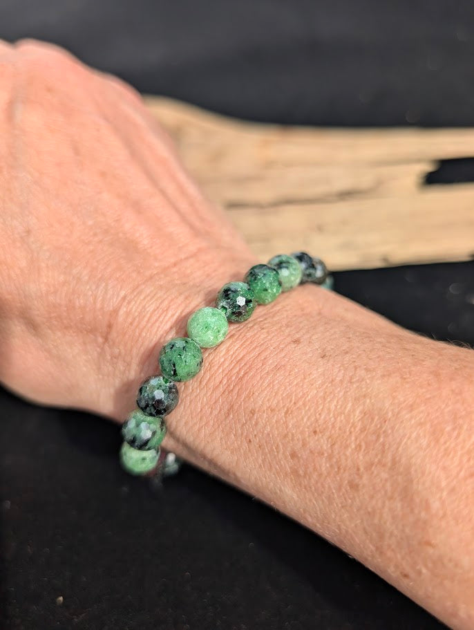 8mm faceted Ruby in Zoisite beaded stretch bracelet worn on a wrist for size scale.