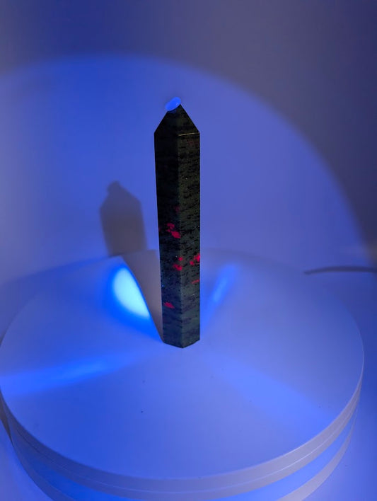 Ruby in Zoisite tower under UV light – fluorescent ruby sections