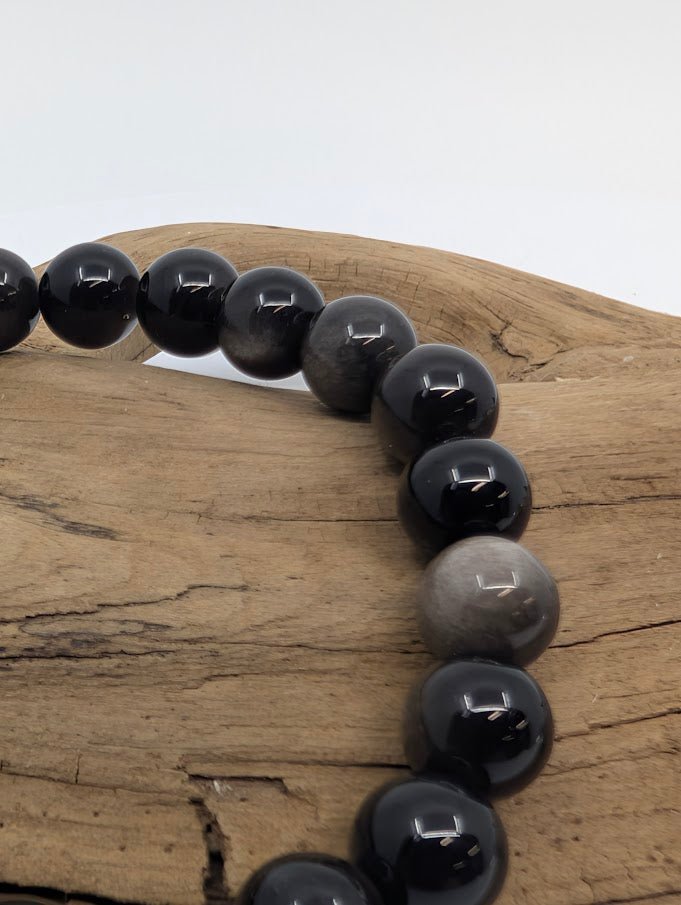 Closeup of silver obsidian beads showing shifting silvery moonlike sheen