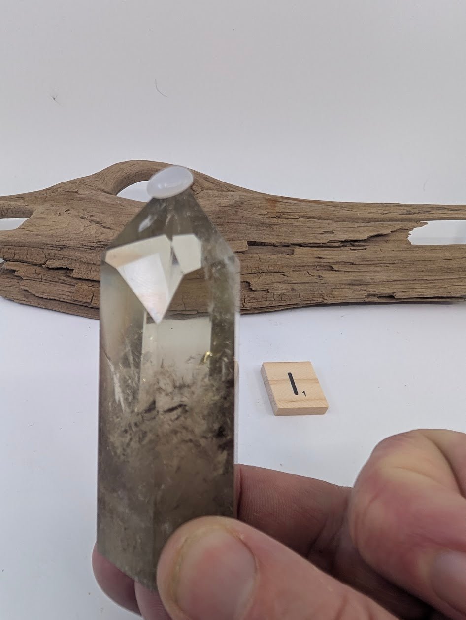 Hand holding Piece I, a 75mm polished Smoky Citrine tower from Brazil with a dramatic dark smoky base.