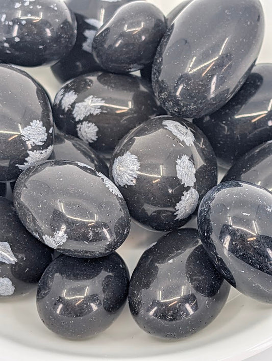 Close-up of Snowflake Obsidian tumbled stones showing gray snowflake inclusions