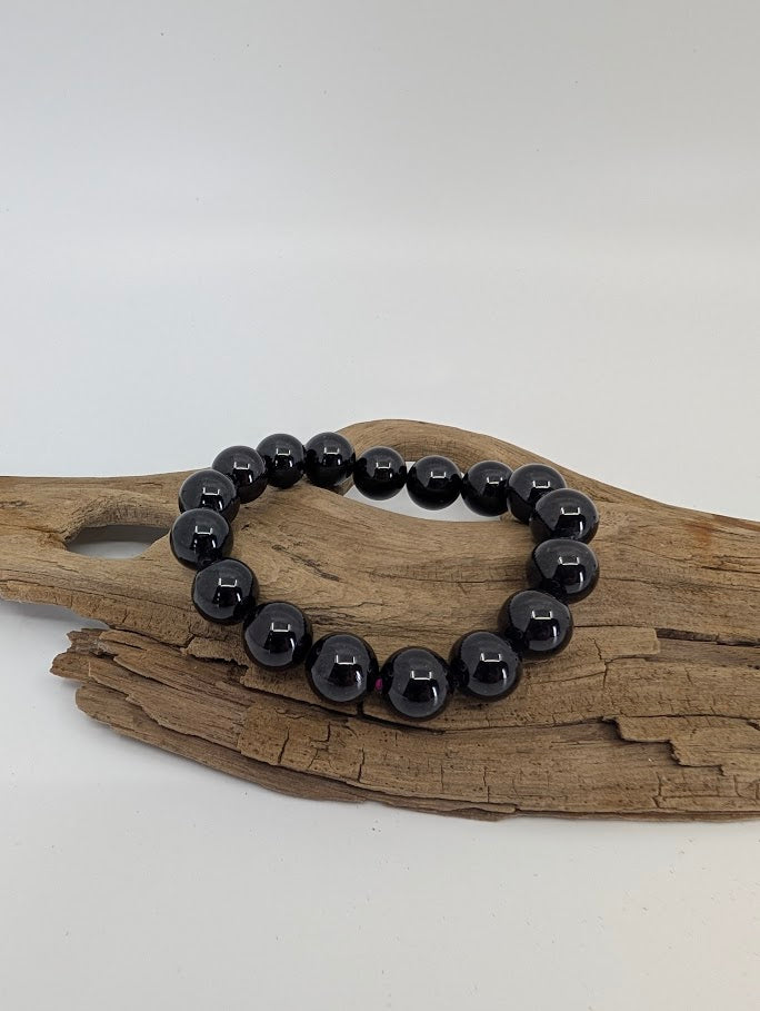 Star flash garnet bracelet in natural light showing glossy dark red beads