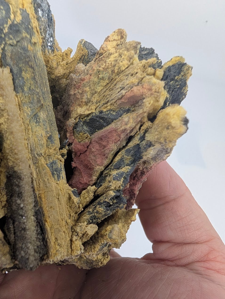 Detailed view of architectural stibnite blade formations coated with sulfur and quartz.