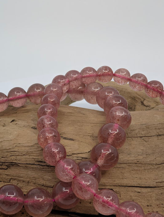 Closeup of Strawberry Quartz beads showing natural pink inclusions and polished finish