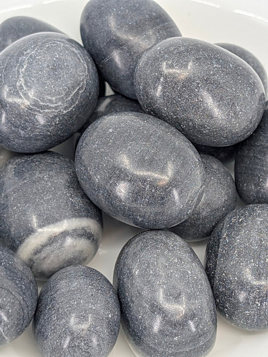 Close-up of Tai Ji Jasper tumbled stones showing black and grey swirls