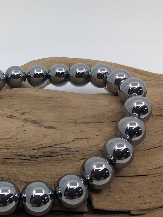 Close-up of polished 8MM Terahertz bracelet beads with metallic sheen