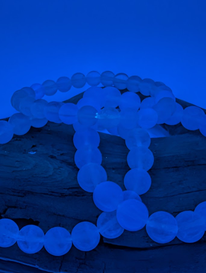 Detailed shot of Velvet Fluorite beads showing gentle fluorescence under blacklight