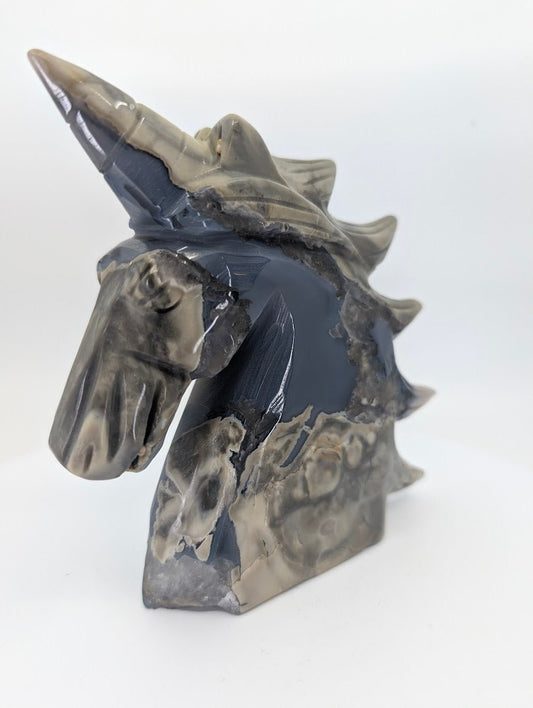 Right profile showing brecciated chalcedony patterns on unicorn carving