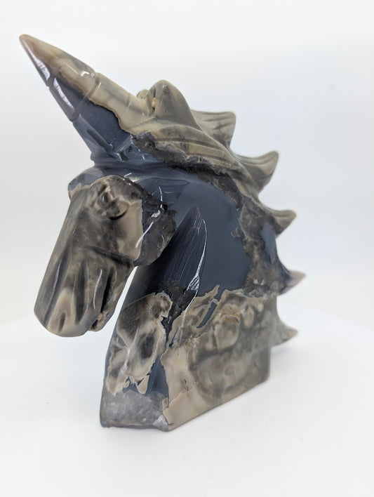 Right profile showing brecciated chalcedony patterns on unicorn carving