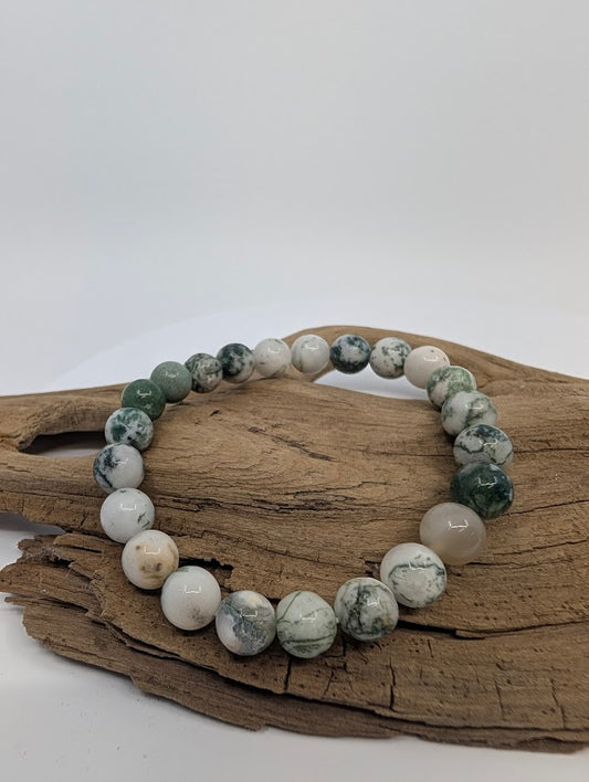8MM White Moss Agate bracelet with green moss-like inclusions displayed on wood