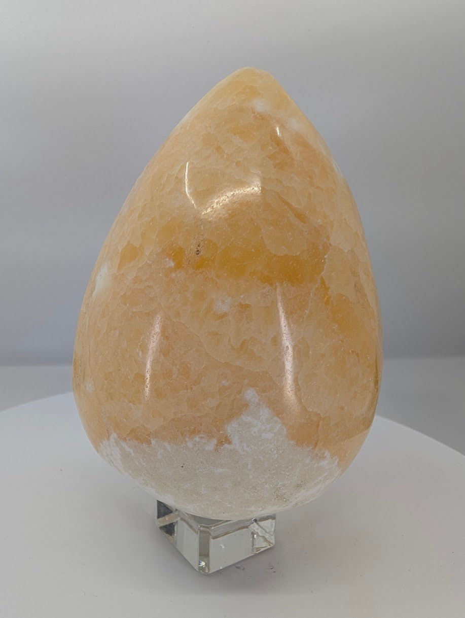 Detail view of a large yellow calcite egg highlighting polish and natural mineral variation