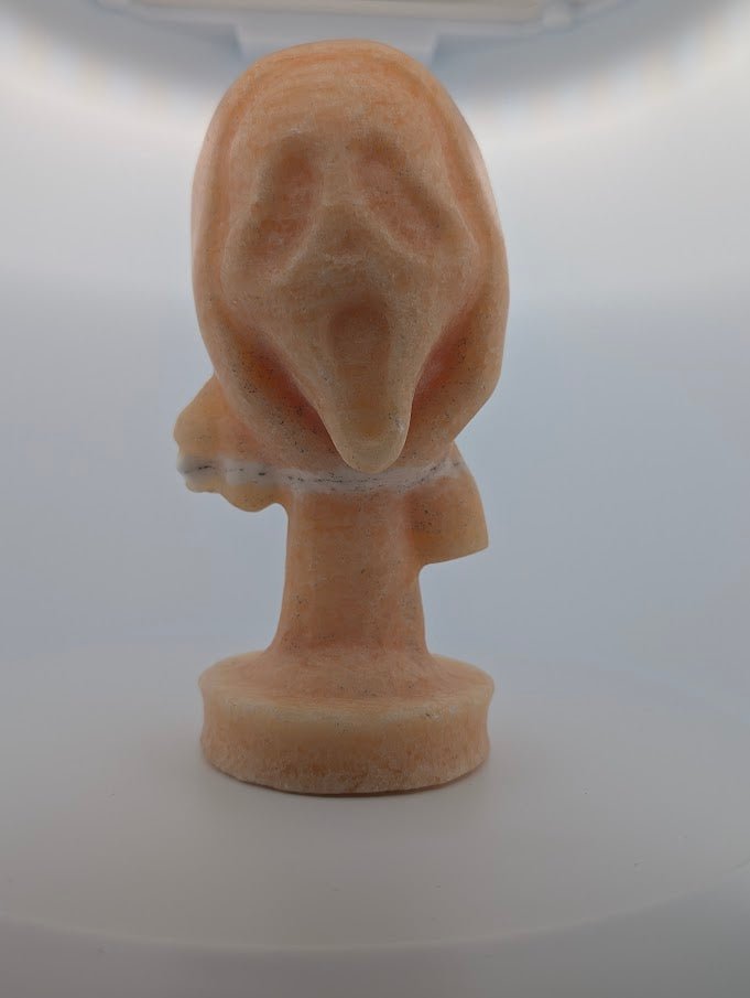 Front view of Yellow Calcite “The Scream” crystal carving, 6 x 3 in, 750g
