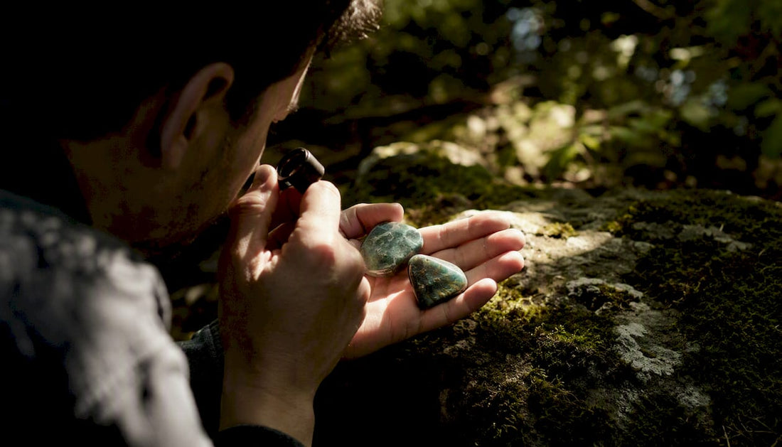 Hands holding jade stones with loupe inspection