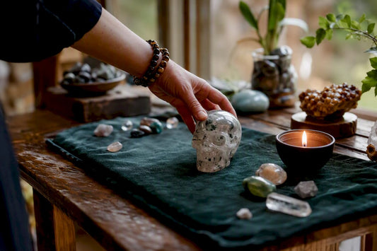 Hand placing carved crystal skull on wooden altar