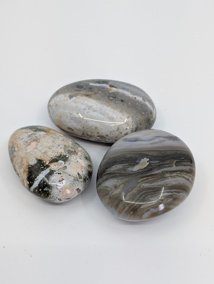 Group of Ocean Jasper Palm Stones showing grey and cream wave-like patterns