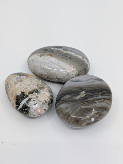 Group of Ocean Jasper Palm Stones showing grey and cream wave-like patterns
