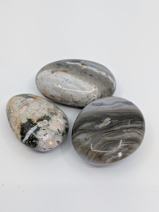 Group of Ocean Jasper Palm Stones showing grey and cream wave-like patterns